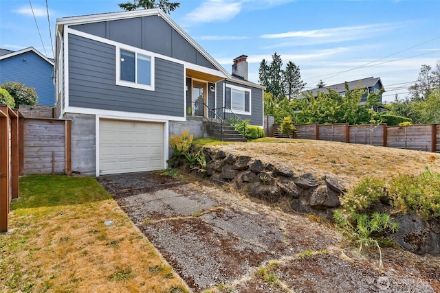 3017 Government Way, Seattle, WA 98199 - view of front of house featuring board and batten siding, an attached garage, driveway, and a chimney