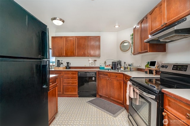 5310 SW College St, Seattle, WA 98116 - kitchen featuring black appliances, under cabinet range hood, light countertops, light floors, and brown cabinets