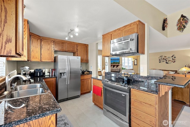 11008 36th Avenue Ct E, Tacoma, WA 98446 - kitchen featuring stainless steel appliances, a breakfast bar area, dark stone countertops, brown cabinetry, and light tile patterned flooring