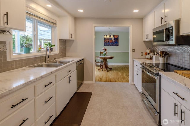 3024 Carpenter Loop SE, Olympia, WA 98503 - kitchen featuring stainless steel appliances, white cabinets, backsplash, recessed lighting, and a chandelier
