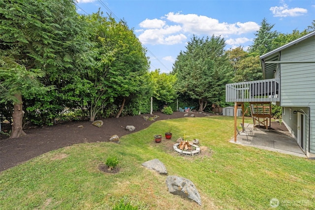 13402 60th Dr SE, Everett, WA 98208 - view of grassy yard featuring a fire pit, a wooden deck, a patio, a storage unit, and stairs