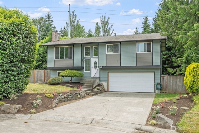 13402 60th Dr SE, Everett, WA 98208 - bi-level home with a garage, concrete driveway, a chimney, and entry steps