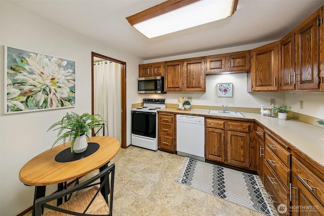 1130 5th Ave S Unit 103, Edmonds, WA 98020 - kitchen with white appliances, light countertops, and brown cabinetry
