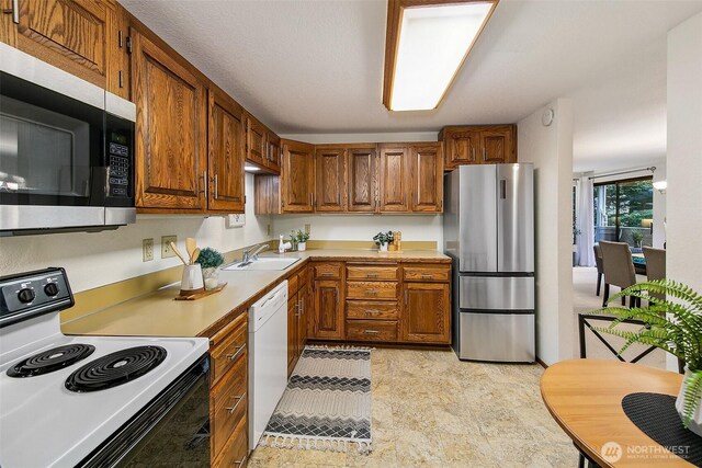 1130 5th Ave S Unit 103, Edmonds, WA 98020 - kitchen with stainless steel appliances, light countertops, and brown cabinets