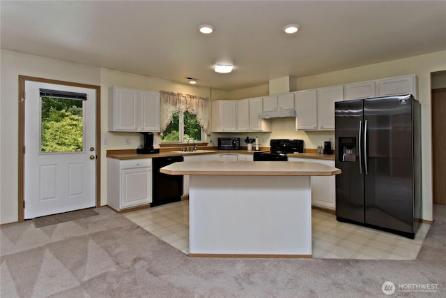 9927 140th St Ct E, Puyallup, WA 98373 - kitchen featuring black appliances, under cabinet range hood, white cabinets, light flooring, and a kitchen island