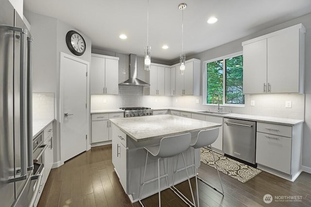 8015 NE 116th Pl, Kirkland, WA 98034 - kitchen with wall chimney exhaust hood, stainless steel appliances, dark wood-style flooring, a center island, and decorative backsplash