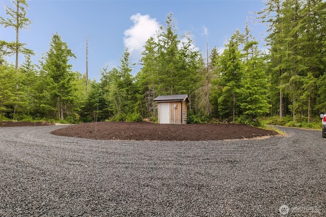 300 E Wild Grape Way, Grapeview, WA 98546 - view of yard with a storage shed and a forest view