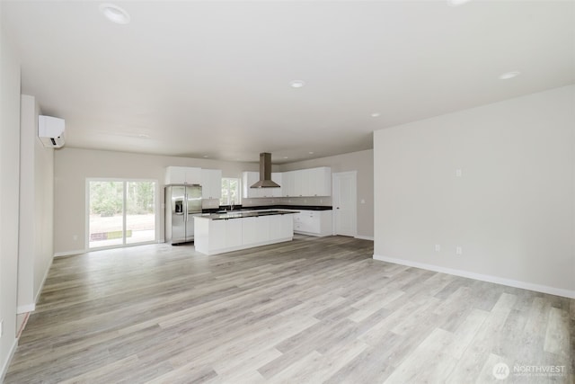 300 E Wild Grape Way, Grapeview, WA 98546 - unfurnished living room featuring an AC wall unit, light wood-type flooring, and recessed lighting