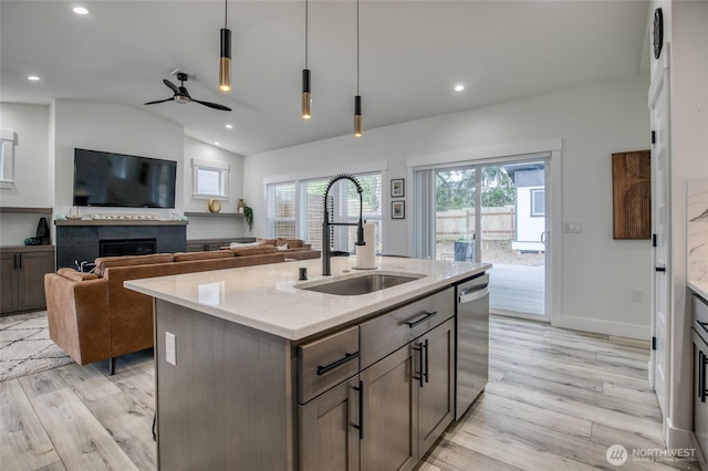 793 Island Cir SE, Ocean Shores, WA 98569 - kitchen featuring light wood-type flooring, dishwasher, a ceiling fan, vaulted ceiling, and a fireplace