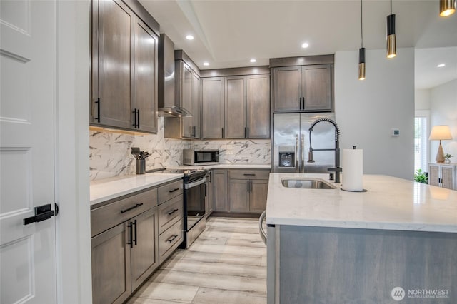 793 Island Cir SE, Ocean Shores, WA 98569 - kitchen featuring appliances with stainless steel finishes, wall chimney range hood, an island with sink, light stone countertops, and decorative backsplash