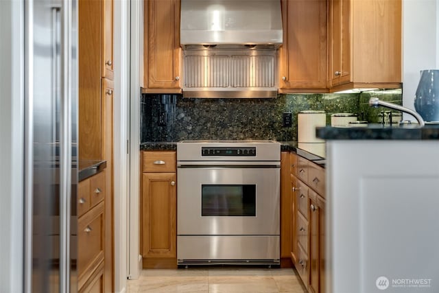 2015 SE Columbia River Dr Unit 320, Vancouver, WA 98661 - kitchen with stainless steel range, tasteful backsplash, brown cabinets, and dark countertops