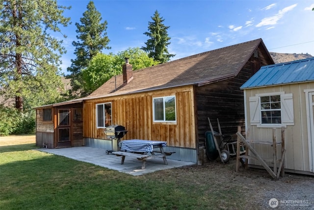 50 Lower Bear Creek Rd, Winthrop, WA 98862 - rear view of house with a yard, a patio area, a chimney, and an outdoor structure