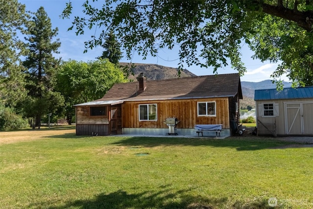 50 Lower Bear Creek Rd, Winthrop, WA 98862 - view of front of property with a shed, a front yard, a chimney, and a mountain view