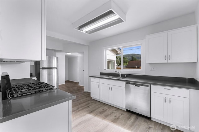 309 Bennett St, Sedro Woolley, WA 98284 - kitchen with appliances with stainless steel finishes, dark countertops, white cabinetry, and light wood-type flooring