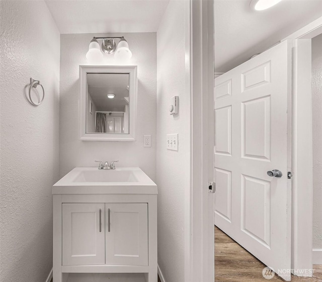 309 Bennett St, Sedro Woolley, WA 98284 - bathroom with wood finished floors, vanity, and a textured wall