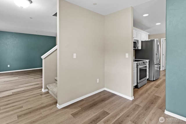 2237 Tolmie St, Dupont, WA 98327 - kitchen with appliances with stainless steel finishes, white cabinets, light wood-style flooring, recessed lighting, and light countertops