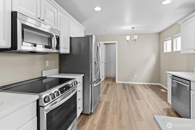 2237 Tolmie St, Dupont, WA 98327 - kitchen with stainless steel appliances, white cabinets, recessed lighting, light wood-style flooring, and a chandelier