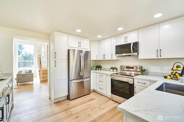 27409 146th Ave SE, Kent, WA 98042 - kitchen with stainless steel appliances, light wood finished floors, light stone countertops, white cabinetry, and recessed lighting