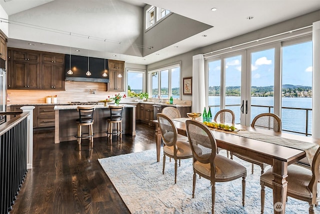 8440 Benotho Pl, Mercer Island, WA 98040 - dining room featuring dark wood-style floors, recessed lighting, a water view, and vaulted ceiling