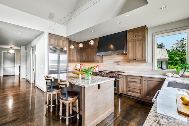 8440 Benotho Pl, Mercer Island, WA 98040 - kitchen with custom range hood, premium appliances, dark wood-type flooring, light stone countertops, and a kitchen island