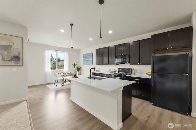 9018 Viola St SE, Tumwater, WA 98501 - kitchen with black appliances, light wood finished floors, an island with sink, recessed lighting, and light countertops