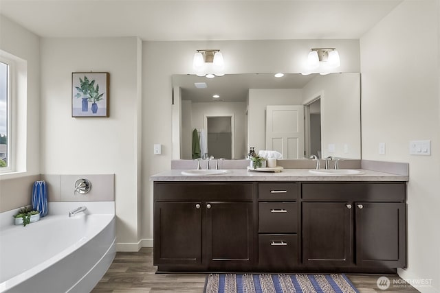 9018 Viola St SE, Tumwater, WA 98501 - bathroom with wood finished floors, double vanity, and a bath