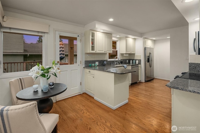 7761 Lakemont Dr NE, Seattle, WA 98115 - kitchen with appliances with stainless steel finishes, light wood finished floors, a peninsula, backsplash, and recessed lighting