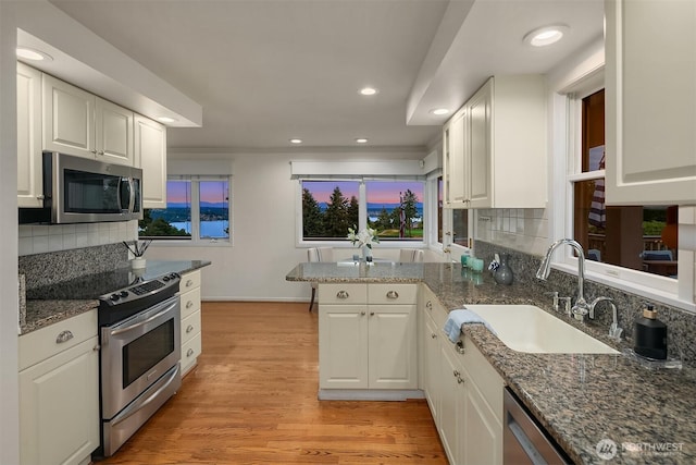 7761 Lakemont Dr NE, Seattle, WA 98115 - kitchen featuring stainless steel appliances, white cabinets, recessed lighting, a peninsula, and tasteful backsplash