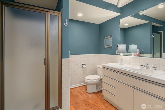 7761 Lakemont Dr NE, Seattle, WA 98115 - full bathroom featuring a stall shower, tile walls, vanity, wood finished floors, and a wainscoted wall