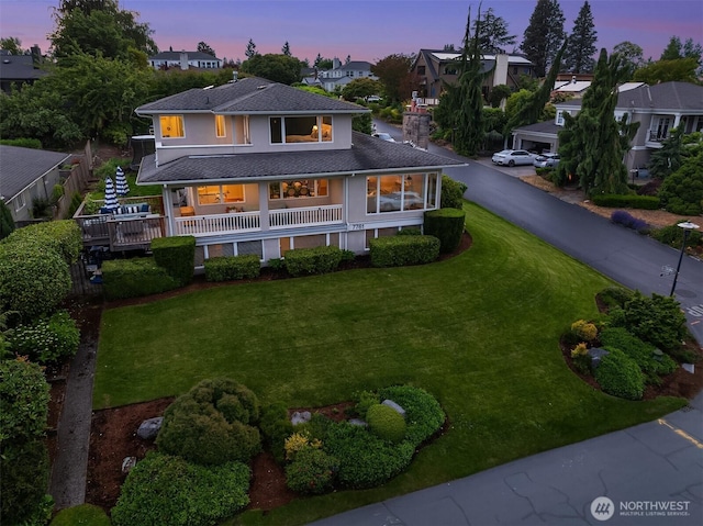 7761 Lakemont Dr NE, Seattle, WA 98115 - back of house at dusk featuring a yard, stucco siding, a residential view, and a shingled roof