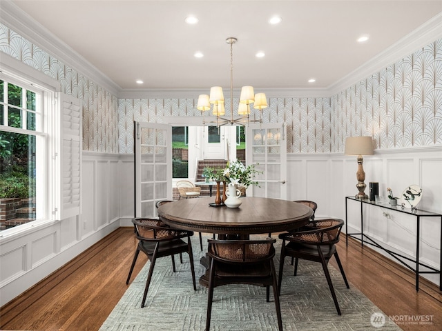 526 W Kinnear Pl, Seattle, WA 98119 - dining room with wallpapered walls, a decorative wall, wood finished floors, a chandelier, and crown molding