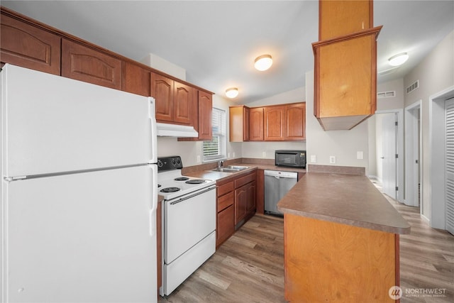 1000 State Route 150 Unit 18, Manson, WA 98831 - kitchen featuring white appliances, a peninsula, under cabinet range hood, light wood-style flooring, and brown cabinetry
