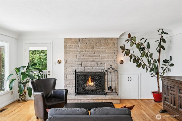 5325 Monta Vista Dr E, Edgewood, WA 98372 - living room featuring healthy amount of natural light, a stone fireplace, and wood finished floors