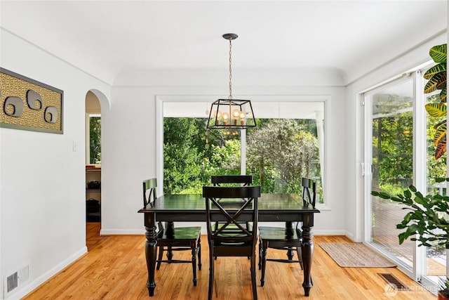 5325 Monta Vista Dr E, Edgewood, WA 98372 - dining area featuring plenty of natural light, arched walkways, a chandelier, and light wood-style flooring