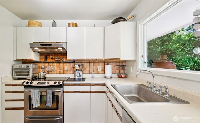 5325 Monta Vista Dr E, Edgewood, WA 98372 - kitchen with under cabinet range hood, stainless steel range with electric cooktop, tasteful backsplash, and white cabinets
