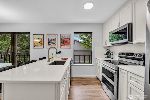 11701 100th Ave NE Unit 2, Kirkland, WA 98034 - kitchen featuring appliances with stainless steel finishes, light countertops, a peninsula, and backsplash