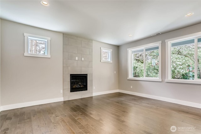 411 205th St SW Unit A, Lynnwood, WA 98036 - unfurnished living room featuring healthy amount of natural light, wood finished floors, a tile fireplace, and recessed lighting
