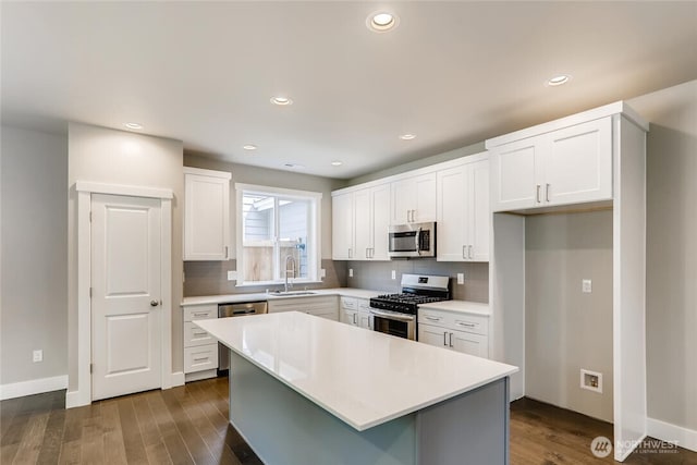 411 205th St SW Unit A, Lynnwood, WA 98036 - kitchen with stainless steel appliances, white cabinetry, backsplash, dark wood finished floors, and light countertops