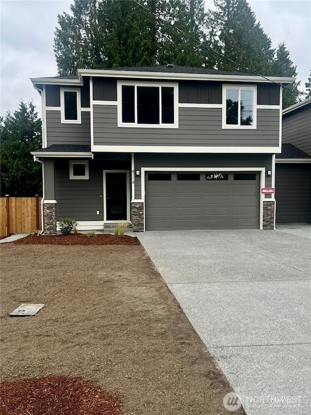 411 205th St SW Unit A, Lynnwood, WA 98036 - view of front facade with an attached garage, stone siding, concrete driveway, and board and batten siding
