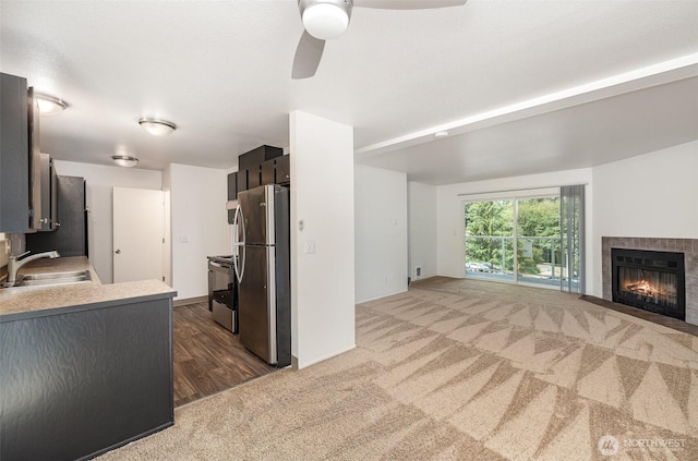 31308 107th Pl SE Unit B1, Auburn, WA 98092 - kitchen featuring stainless steel appliances, a ceiling fan, carpet floors, a tiled fireplace, and light countertops