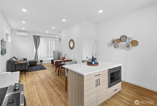 9228 21st Ave SW, Seattle, WA 98106 - kitchen with stainless steel microwave, a wall mounted air conditioner, modern cabinets, light wood-style floors, and recessed lighting