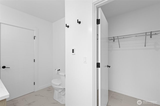 9228 21st Ave SW, Seattle, WA 98106 - bathroom featuring marble look tiles, a spacious closet, and vanity