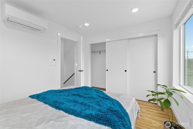 9228 21st Ave SW, Seattle, WA 98106 - bedroom featuring a wall mounted AC, a closet, wood finished floors, and recessed lighting