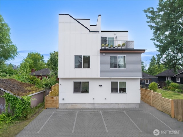 9228 21st Ave SW, Seattle, WA 98106 - rear view of house with uncovered parking, a balcony, and a patio area
