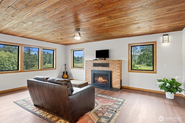 13402 Spring Site Rd E, Orting, WA 98360 - living area with wood ceiling, a fireplace, wood finished floors, and ceiling fan