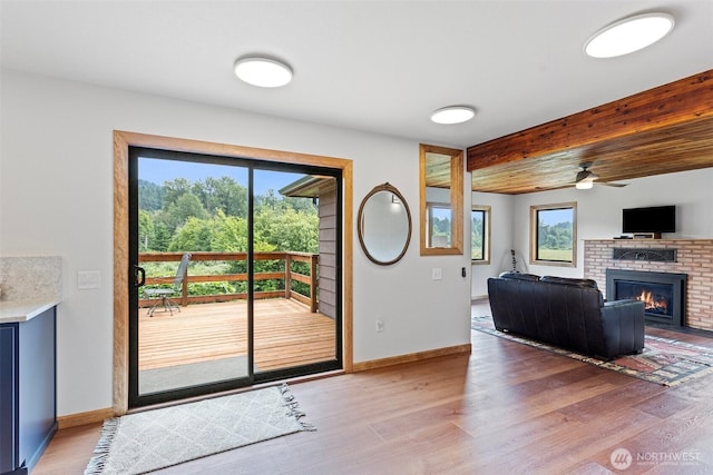 13402 Spring Site Rd E, Orting, WA 98360 - doorway to outside with a brick fireplace, light wood finished floors, and a ceiling fan
