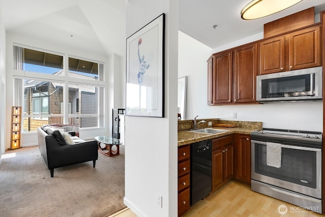 225 Logan Ave S Unit B355, Renton, WA 98057 - kitchen featuring stainless steel appliances, lofted ceiling, dark stone countertops, and light wood-style flooring