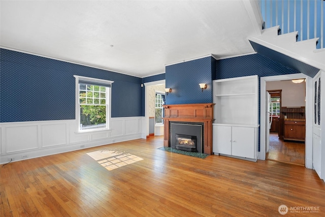 3402 N 28th St, Tacoma, WA 98407 - unfurnished living room with wallpapered walls, wainscoting, hardwood / wood-style floors, a fireplace with flush hearth, and crown molding