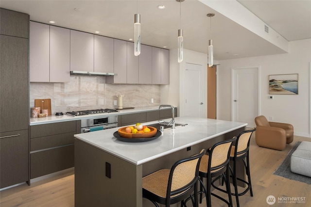 2510 6th Ave Unit 3605, Seattle, WA 98121 - kitchen with light wood finished floors, tasteful backsplash, gray cabinetry, and light countertops