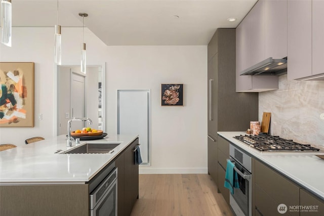 2510 6th Ave Unit 3605, Seattle, WA 98121 - kitchen featuring wall chimney range hood, appliances with stainless steel finishes, light wood-style flooring, decorative backsplash, and light countertops